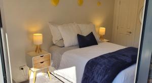 1 dormitorio con 1 cama con 2 lámparas en Takapuna Beach Accommodation, en Auckland