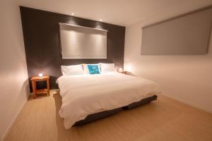 een slaapkamer met een groot bed met 2 verlichting bij Firefly Apartments in Hakuba