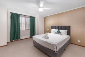 Schlafzimmer mit einem großen Bett und grünen Vorhängen in der Unterkunft Yarra Valley Motel in Lilydale