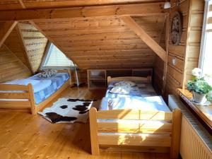 a room with two beds in a log cabin at Apartament Suzyw Kicek in Sucha Beskidzka