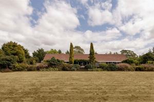 una casa con un gran campo delante de ella en The 540 Lodge en Masterton
