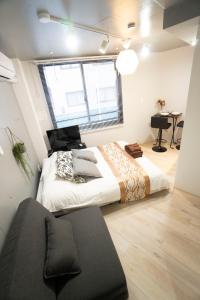 東京にあるHill Side Terrace Hiroo Shibuya 201の大きなベッドと机のある寝室