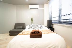東京にあるHill Side Terrace Hiroo Shibuya 201のタオルが敷かれたベッドのある寝室