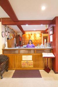 Una donna in piedi dietro un bar in un ristorante di S.K.House 2 a Chiang Mai