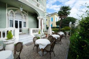 a patio with tables and chairs on a house at Hotel Gennarino in Livorno