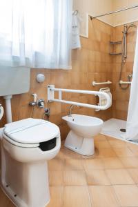 a white toilet sitting next to a white sink at Hotel Gennarino in Livorno