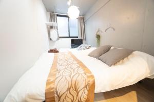 - une chambre avec un grand lit et des draps blancs dans l'établissement Hill Side Terrace Hiroo Shibuya 203, à Tokyo