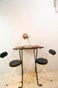 a table with chairs and a vase of flowers on it at Hill Side Terrace Hiroo Shibuya 203 in Tokyo