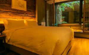 Schlafzimmer mit einem großen weißen Bett und einem Fenster in der Unterkunft TOP ZERO HOTEL in Wudangshan