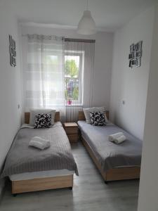 1 dormitorio con 2 camas y ventana en Rokicinska54 com en Lodz