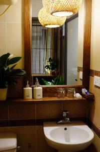 y baño con lavabo y espejo. en The Autumn Homestel, en Hanói