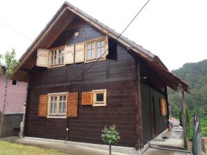 a small wooden house with windows at Stara Planina Stankovic in Crni Vrh