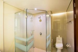 a bathroom with a glass shower with a toilet at Golden Palace Hotel Lombok in Mataram