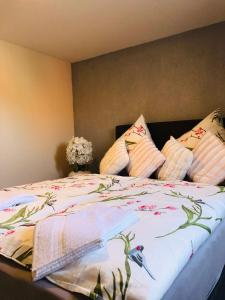 ein Schlafzimmer mit einem Bett mit Blumen und Kissen in der Unterkunft Noblesse Hause in Gammertingen