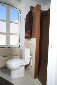 a bathroom with a toilet and a window and a shower at Studio Rosmarin in Faro