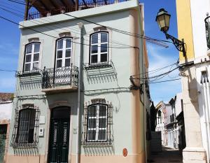 a white building with balconies and a street light at Studio Rosmarin in Faro