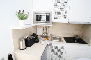 a small kitchen with a sink and a microwave at Studio Rosmarin in Faro