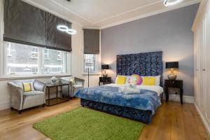 a bedroom with a blue bed and a green rug at Apartment on Duke Street in London