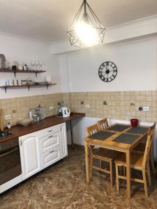 a kitchen with a table and a clock on the wall at Apartamenty Brzózki in Brzózki