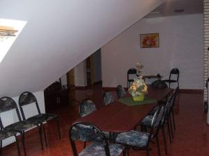 a dining room with a wooden table and chairs at Hubertus Vendégház in Parád