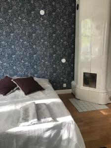 1 dormitorio con cama blanca y chimenea en Willa Strand, en Kristinestad
