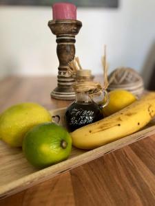 een houten plank met fruit en een fles jam en een citroen bij Hoeperhof in Bötersen