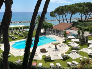uma vista para a piscina e para o oceano a partir do resort em La Casa di Anny camere di Charme Citr 8027 em Diano Marina