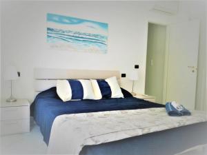 a bedroom with a bed with blue sheets and white pillows at Casa Solemare in Diano Marina