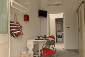 a room with a table and two chairs and a kitchen at Monolocale Citronella a due passi dal mare in San Pietro in Bevagna