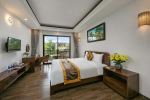 ein Hotelzimmer mit einem Bett und einem Balkon in der Unterkunft Villa Blake Hoi An in Hoi An