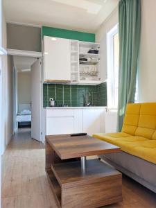 - un salon avec un canapé jaune et une table dans l'établissement Guest House Bolnisi - Green Apartment, à Bolnisi