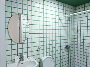 La salle de bains est pourvue d'un lavabo, de toilettes et d'un miroir. dans l'établissement Guest House Bolnisi - Green Apartment, à Bolnisi