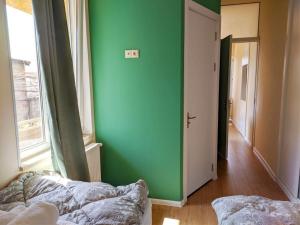 a green room with a bed and a window at Guest House Bolnisi - Green Apartment in Bolnisi
