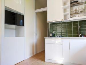 a kitchen with white cabinets and a flat screen tv at Guest House Bolnisi - Green Apartment in Bolnisi