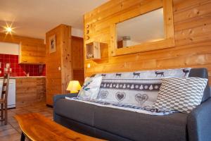 a living room with a couch and a table at Chalet LES MURZIERS in Notre-Dame-de-Bellecombe