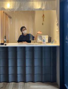 a man sitting at a counter in a bathroom at 04village Namba in Osaka