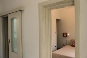 a bedroom with a door leading to a bed at Monolocale Citronella a due passi dal mare in San Pietro in Bevagna