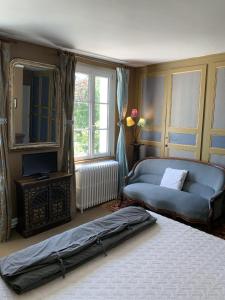 Saint-Aubin-sur-Scieにあるシャンブル ドット ヴィラ モン ルポのベッドルーム(ベッド1台、ソファ、鏡付)
