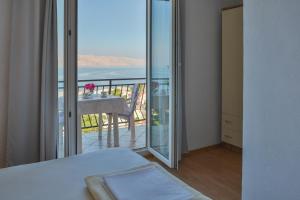 a bedroom with a balcony with a view of the ocean at Holiday Apartments Soparin in Senj
