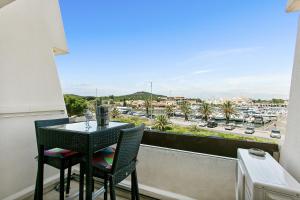 a table and chairs on a balcony with a view of a city at L'After Port Nature in Cap d'Agde