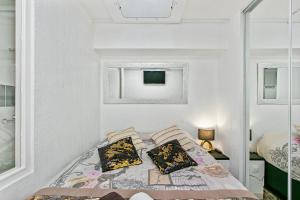 a small bedroom with a bed and two pillows at L'After Port Nature in Cap d'Agde +4 photos