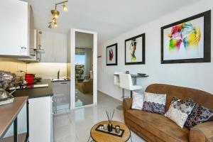 a living room with a couch and a kitchen at L'After Port Nature in Cap d'Agde