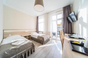 a hotel room with two beds and a desk at Admiral II in Świnoujście