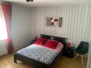 サント・メール・エグリーズにあるGîtes de l'Eglise WACOのベッドルーム1室(赤い枕のベッド1台付)