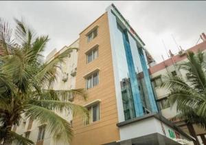 a tall building with palm trees in front of it at Hotel Sai SK Palace in Shirdi