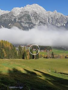 un campo nebbioso con un pallone da calcio davanti a una montagna di Appartement Haus Petra a Leogang