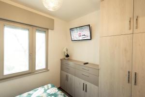 una camera da letto con cassettiera e finestra di Cattleya a Grado