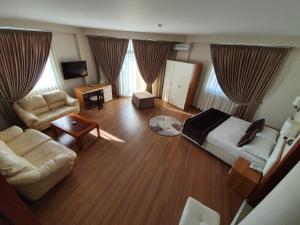 a bedroom with a bed and a couch and a table at Hotel Arvi in Durrës