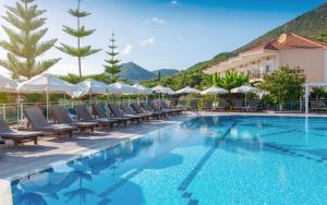 a hotel swimming pool with chairs and umbrellas at Alea Resort in Parga