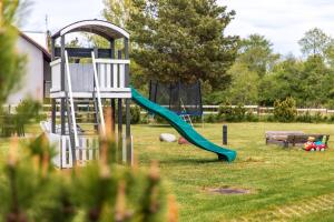 ein Spielplatz mit Rutsche im Hof in der Unterkunft Apartamentai Upė in Šventoji